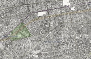 The image shows a city grid of streets divided into blocks. A green area on the left side indicates a park. 